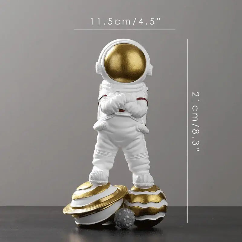 Decorbites astronaut figurine abstract sculpture in white with a gold helmet standing on two golden striped planets for modern decor
