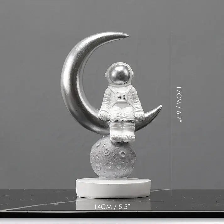 Silver decorbites astronaut figurines sitting on crescent moon with textured base modern spaceman sculpture gift idea