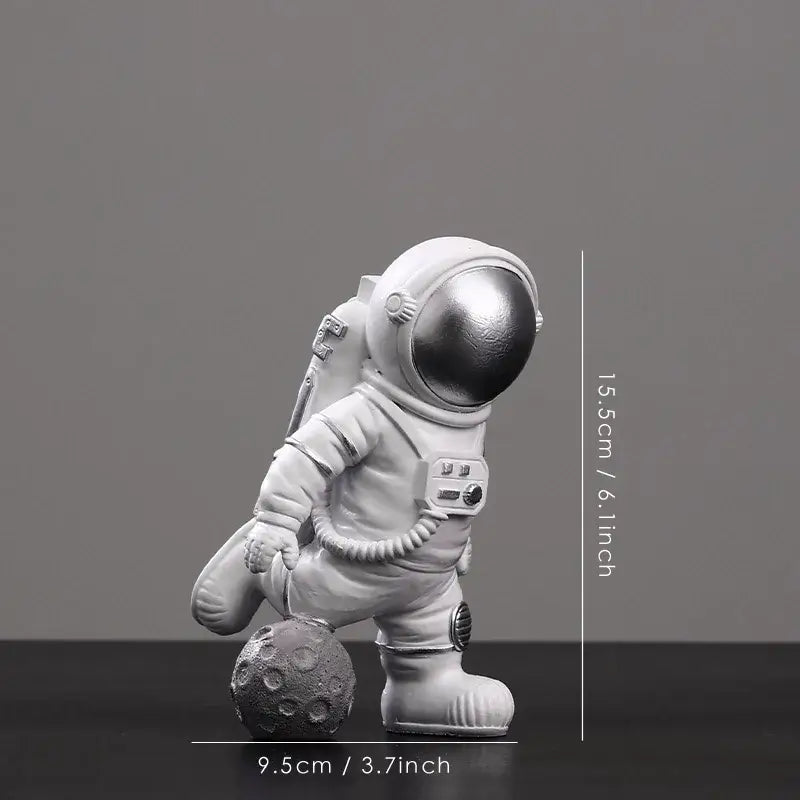 White astronaut figurine with metallic silver helmet on textured gray moon surface from decorbites astronaut figurines