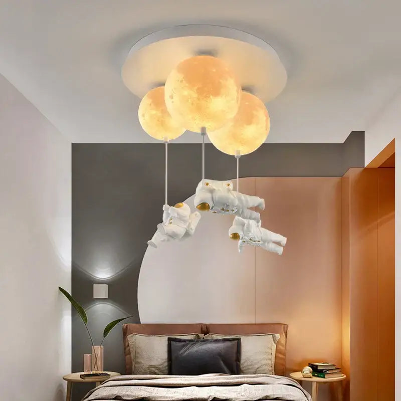 Three glowing textured moon shaped ceiling lights by decorbites astronaut globe with floating astronaut figures for kids room