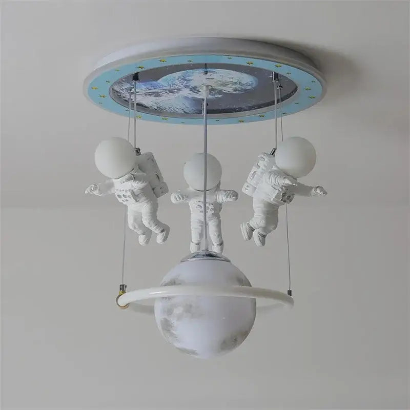 White DecorBites astronaut LED ceiling light featuring three floating astronauts and a central planet for children’s rooms