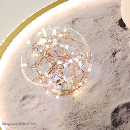 A clear glass globe filled with glowing copper wire fairy lights in decorbites astronaut led ceiling light