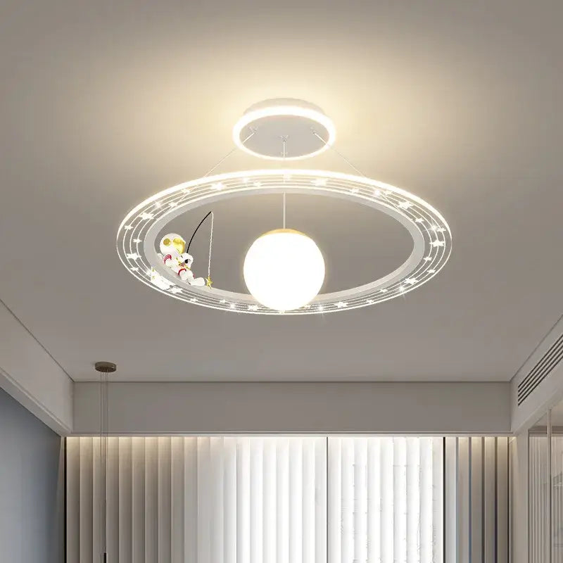 Modern white circular astronaut led chandelier with central orb and figurine fishing on ring for child’s room by decorbites