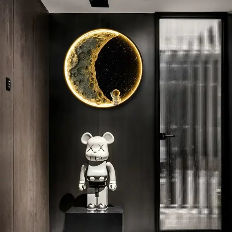 A white kaws be@rbrick figure on a dark pedestal beside the modern nordic resin decorbites led wall lamp