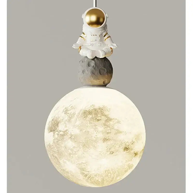 A decorbites astronaut lunar pendant light featuring a white astronaut figurine with gold helmet over an illuminated moon globe