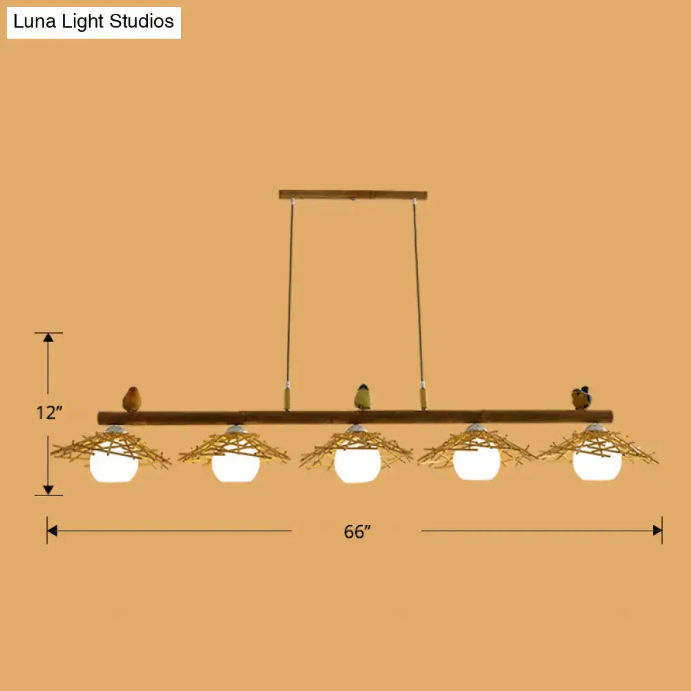 Decorbites bamboo pendant lighting featuring rustic wooden beam with five white glass globe bulbs and art deco bird accents