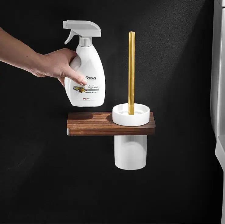 Gold toilet brush with white ceramic holder on dark wood shelf from decorbites bathroom hardware set in space aluminum