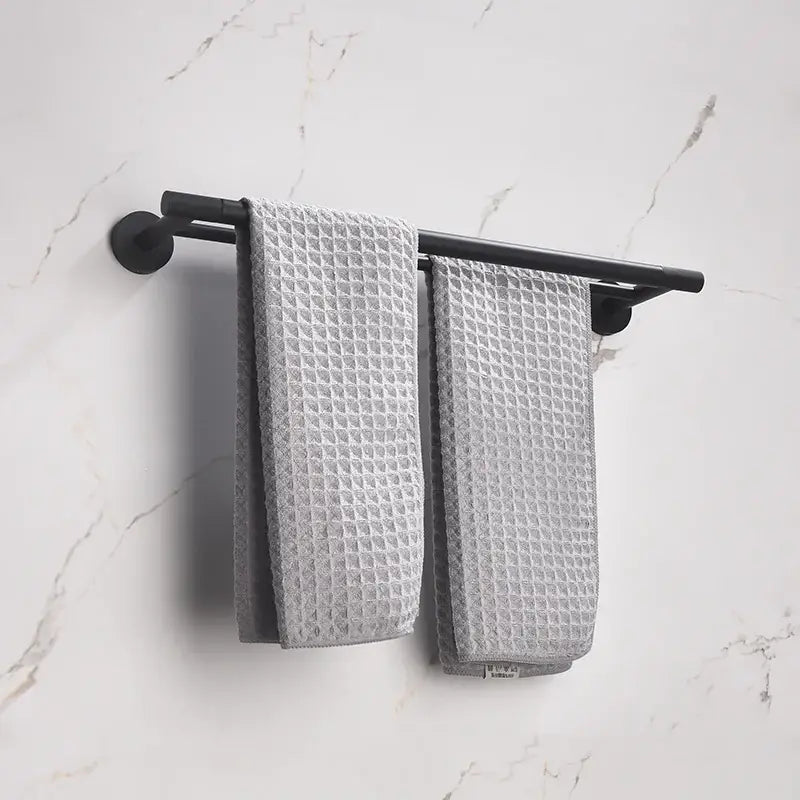 Black matte finished towel rack holding two gray waffle weave towels in decorbites bathroom hardware set