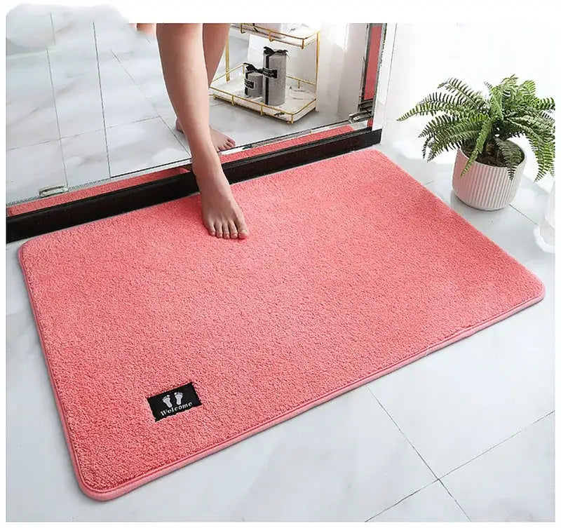 Pink rectangular decorbites bathroom mat with plush texture and black welcome patch super non slip and absorbent