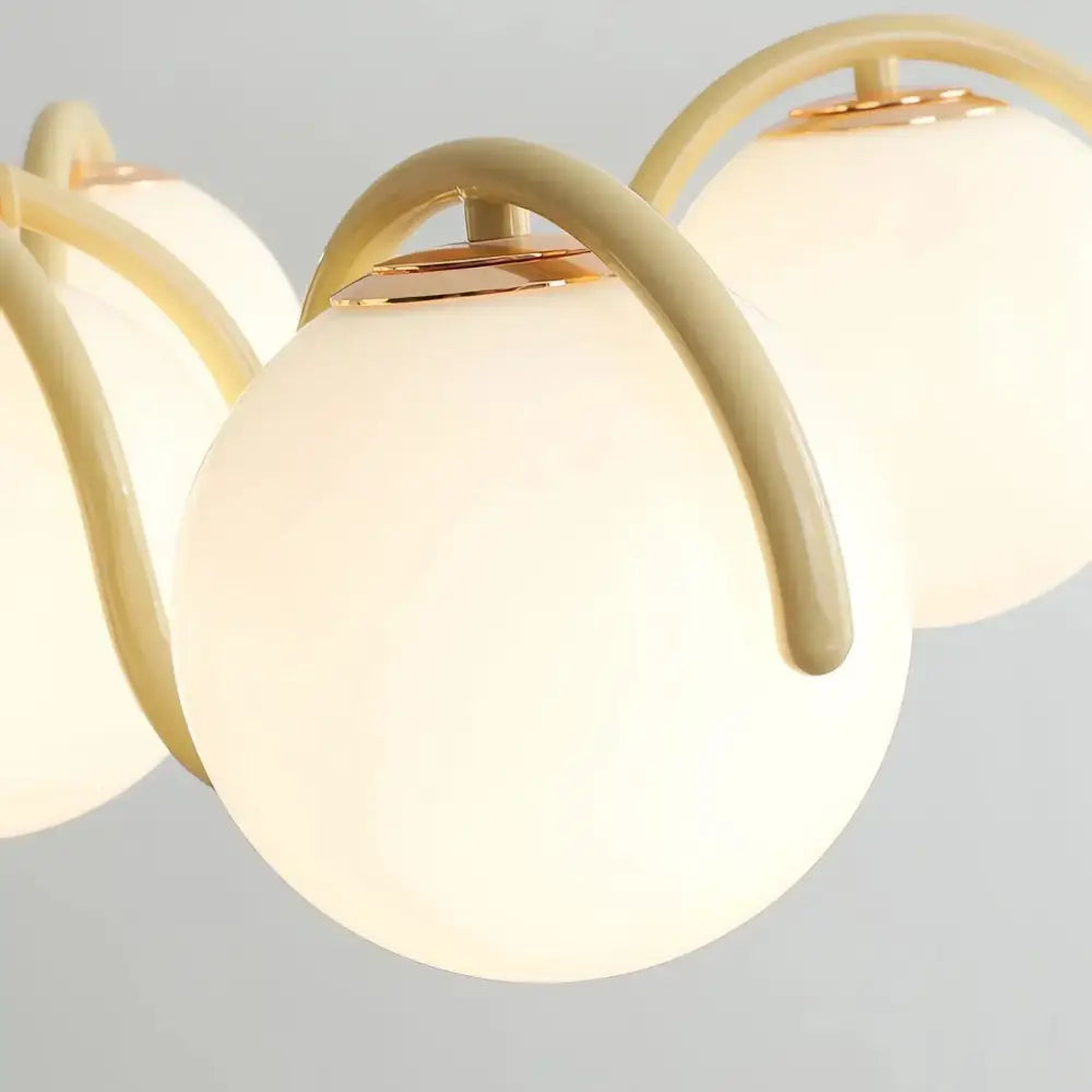 Cream-colored spherical glass globe pendant light with gold metal arms decorbites bean glass for living room use