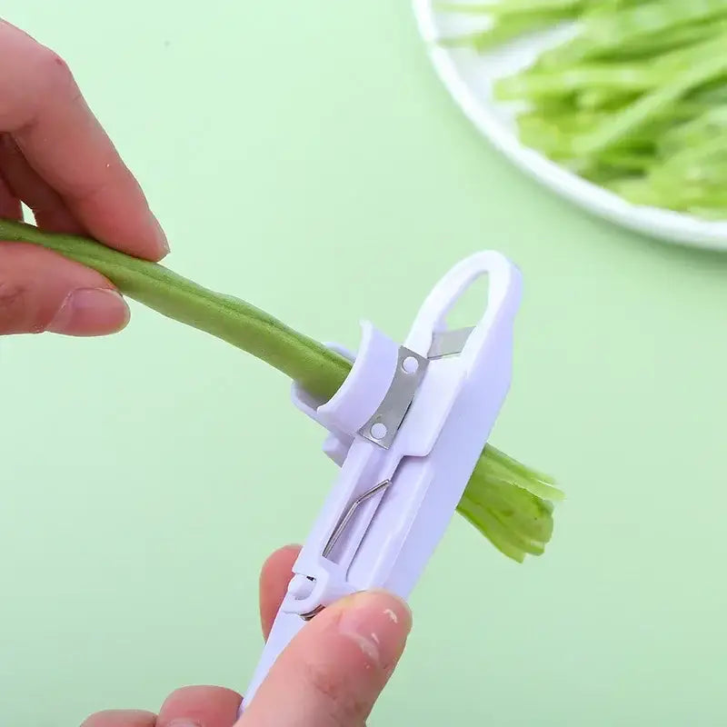 White plastic decorbites bean slicer cutter with metal blade for peeling and stringing green beans in kitchen use