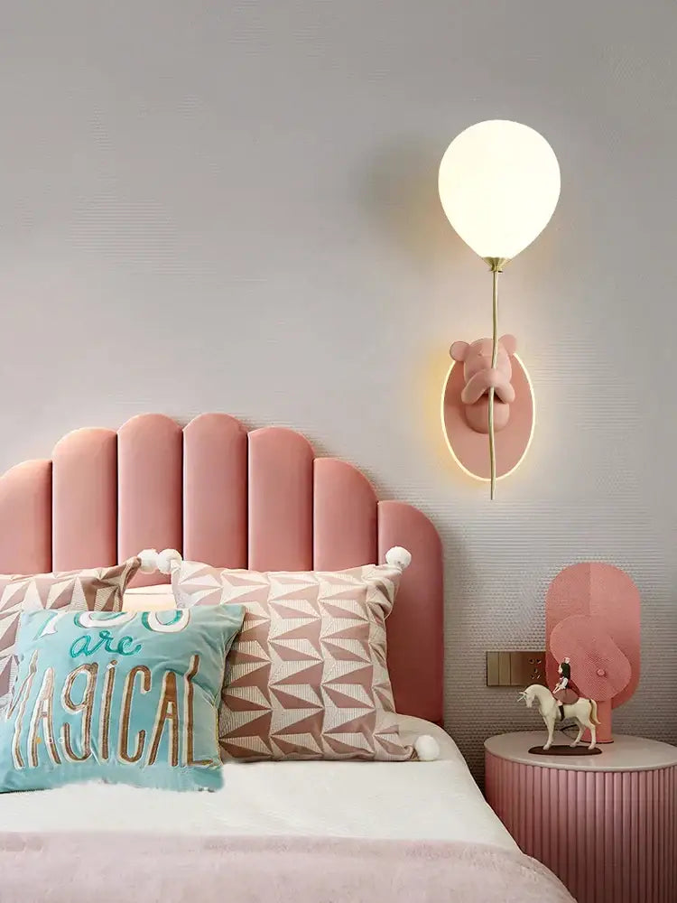 A soft pink wall lamp with a gold-toned stem and plush bear face base from decorbites bear artistic kids collection