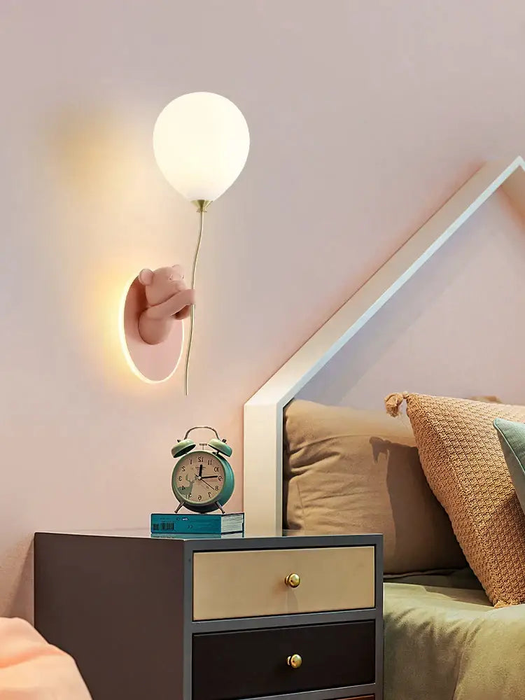 Decorbites bear artistic kids wall lamp featuring a pink hand holding a soft white balloon-shaped light fixture