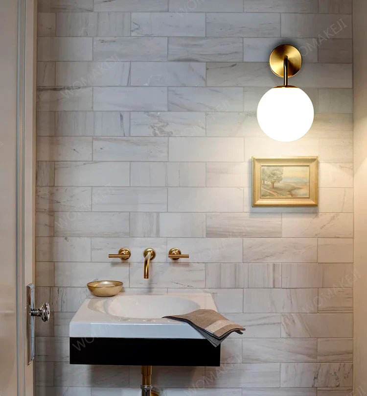 Bathroom sink with gold fixtures illuminated by DecorBites™ black battery operated wall sconces with remote control