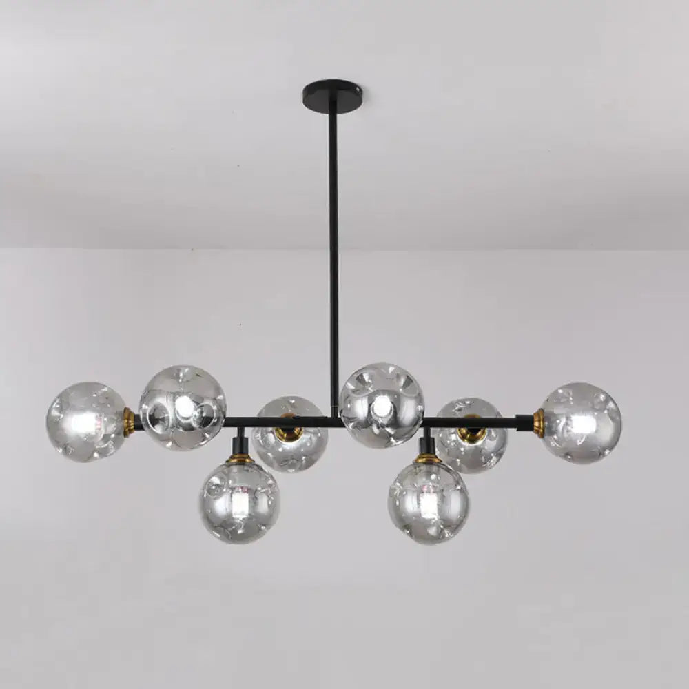 Modern black metal chandelier light type with clear glass globe bulbs and brass accents for dining room island lighting