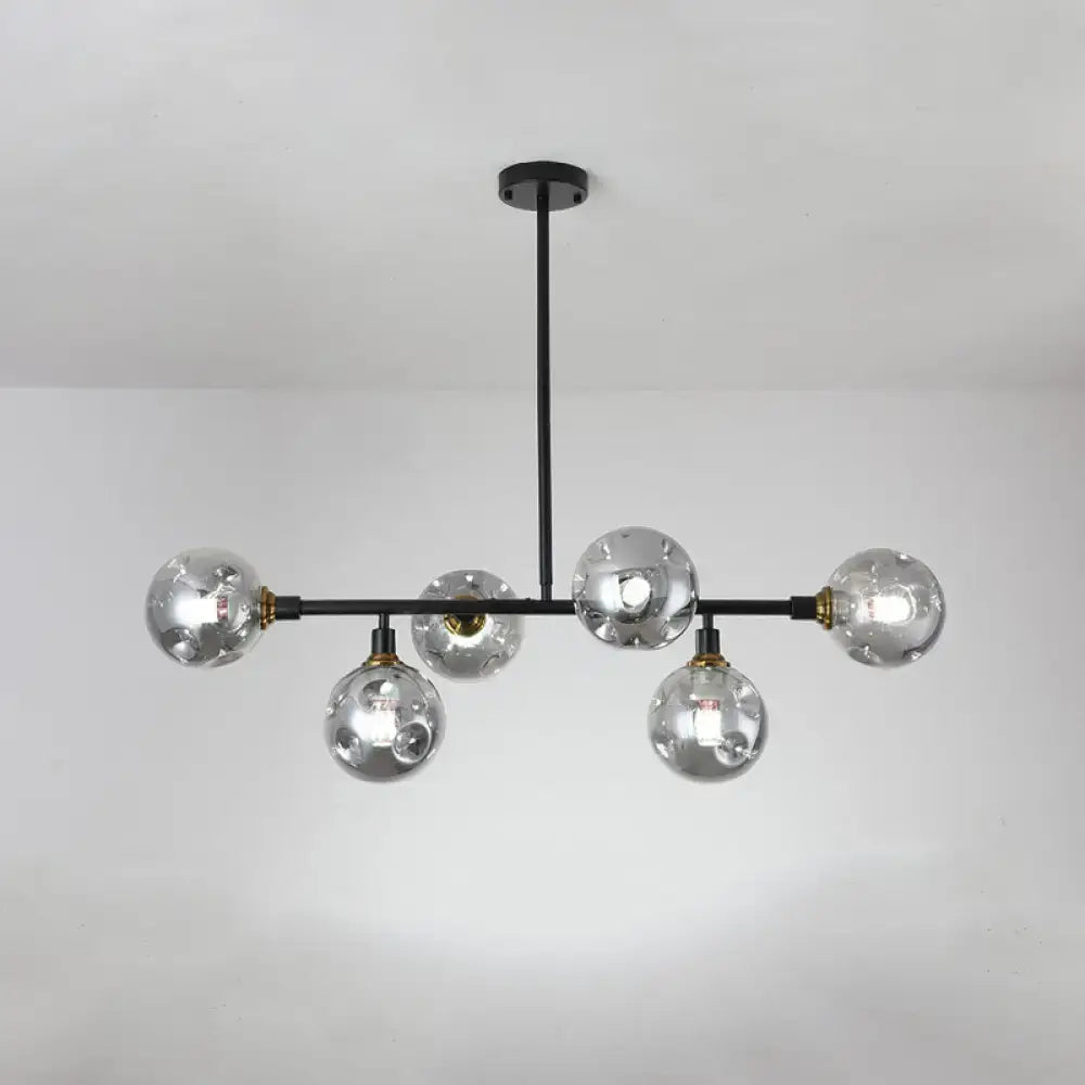 Modern black metal chandelier light type with five clear glass globe bulbs and brass accents for dining room island