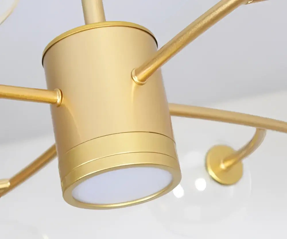 Gold-toned cylindrical ceiling light fixture with brushed metal finish complementing decorbites black glass ball molecule chandelier