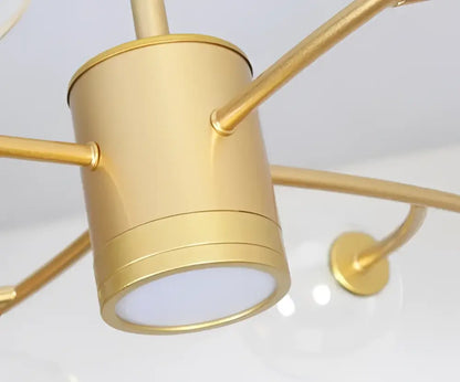 Gold-toned cylindrical ceiling light fixture with brushed metal finish complementing decorbites black glass ball molecule chandelier