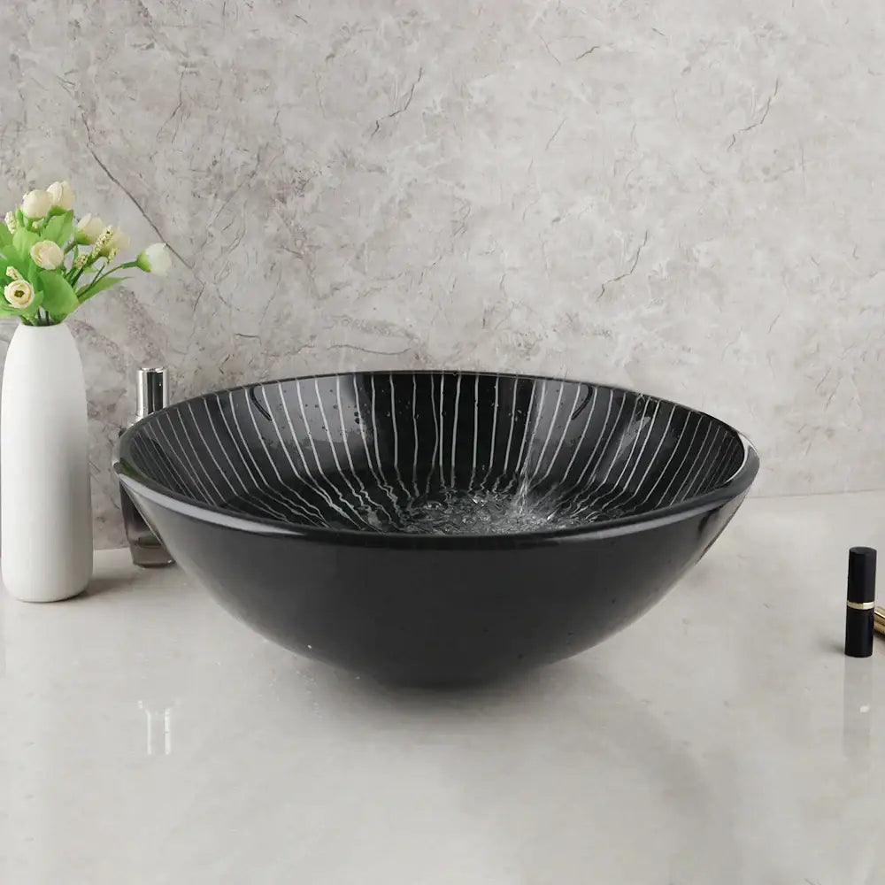 Decorbites black glass bathroom sink set featuring a black glass vessel sink with subtle white radial stripes and waterfall faucet