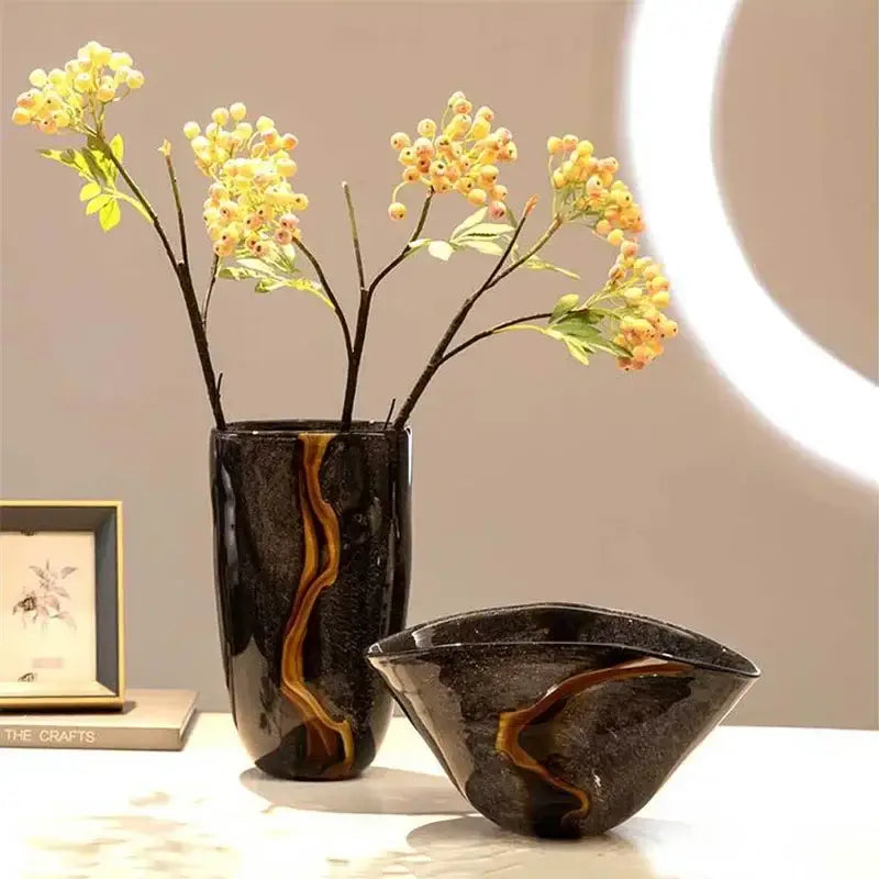 Decorbites black glass vase featuring glossy black ceramic with amber-gold marbled patterns for floral arrangement