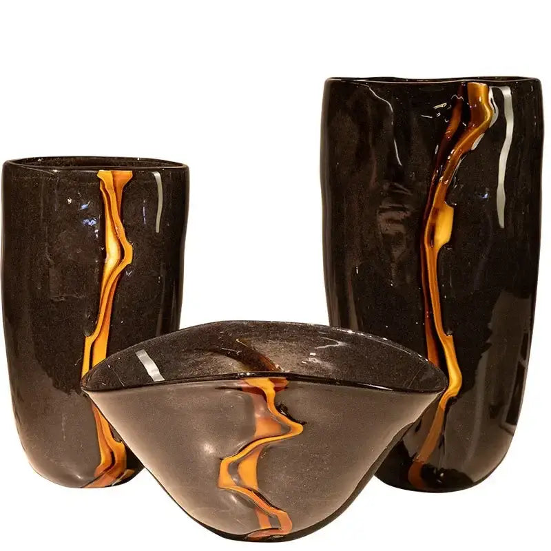 Set of three decorbites black glass vases with flowing amber and gold streaks for floral arrangement and room decoration