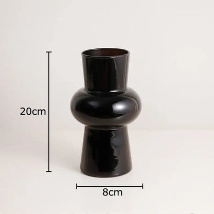 A sleek black glass vase by DecorBites with a glossy ceramic finish and artificial flowers for stylish decor