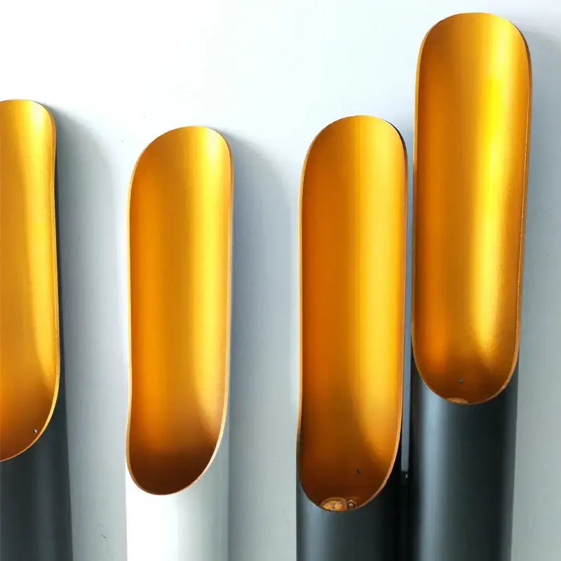 DecorBites black gold aluminum tube wall sconce with golden elongated metallic scoops on dark gray cylindrical bases