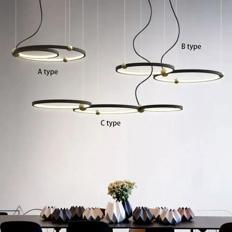 Modern minimalist decorbites black gold chandelier with sleek black metal rings and warm led gold-toned spherical accents