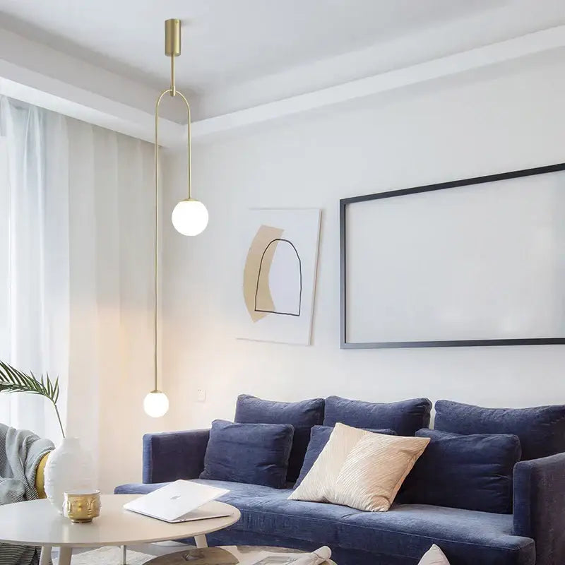 A decorbites black gold chandelier pendant featuring two spherical bulbs on a curved gold-toned arm in modern style
