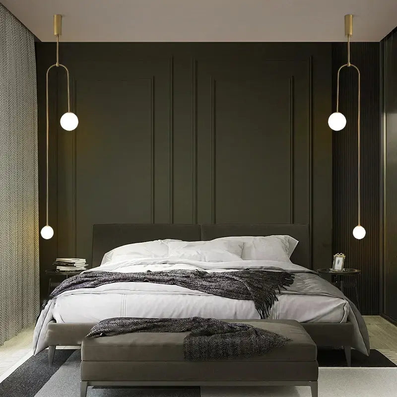 Modern gold-toned decorbites black gold chandelier pendant with spherical bulbs hanging symmetrically above bed