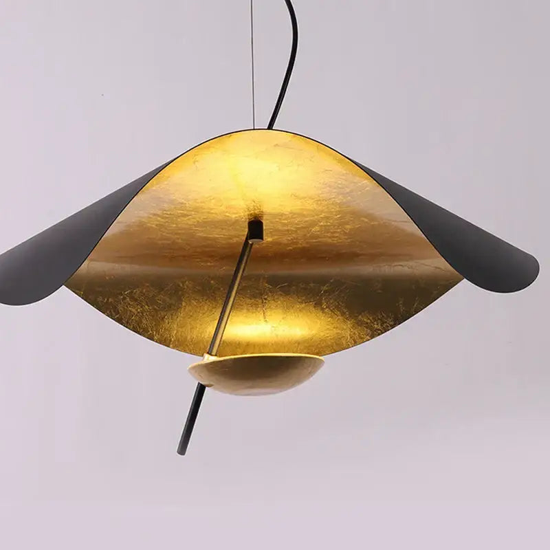 Golden leaf-shaped pendant light with matte black underside and central stem from decorbites black gold collection