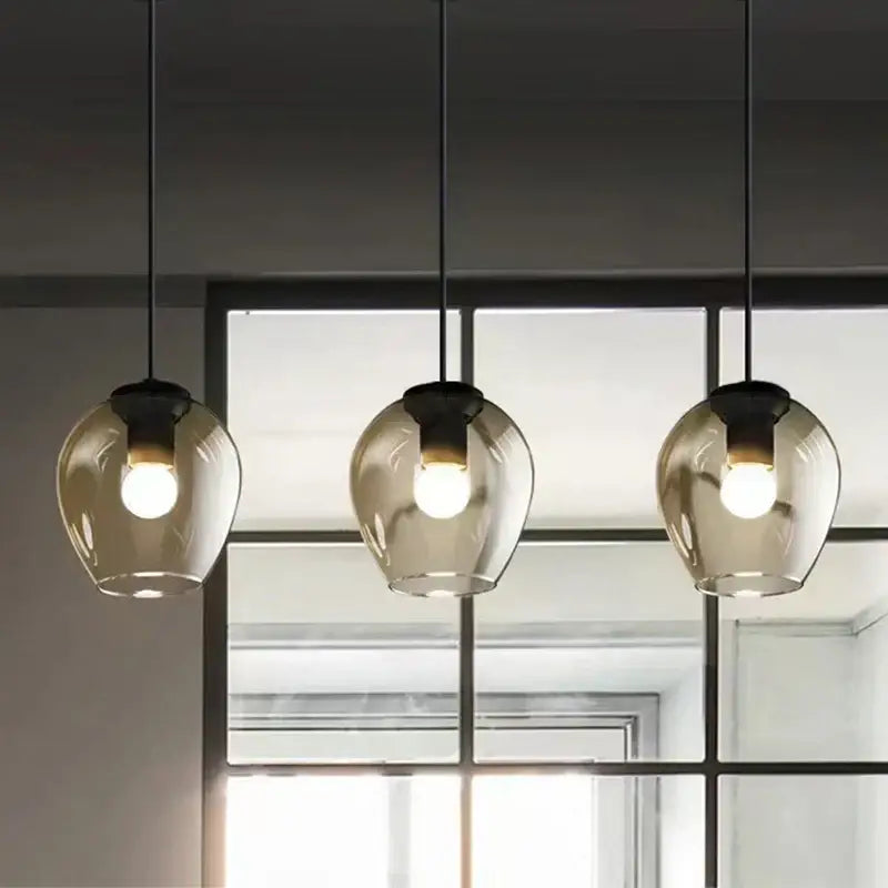 Three hanging pendant wall lamps with translucent amber glass globes and black gold metal fixtures by decorbites black gold