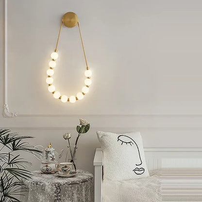Gold-toned decorbites black gold led wall lamp with circular top and glowing spherical bulbs for bedroom and corridor