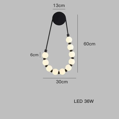 DecorBites black gold led wall lamp features cream spherical bulbs on black cords in an elegant teardrop shape