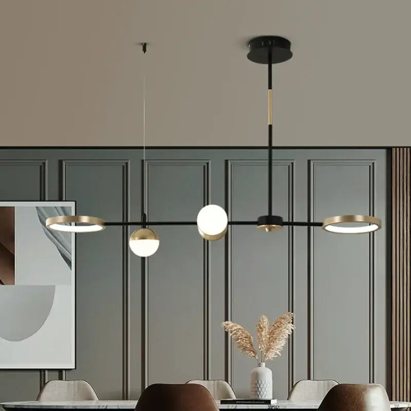Decorbites black gold minimalist chandelier with three black and gold spherical bulbs for dining room decor
