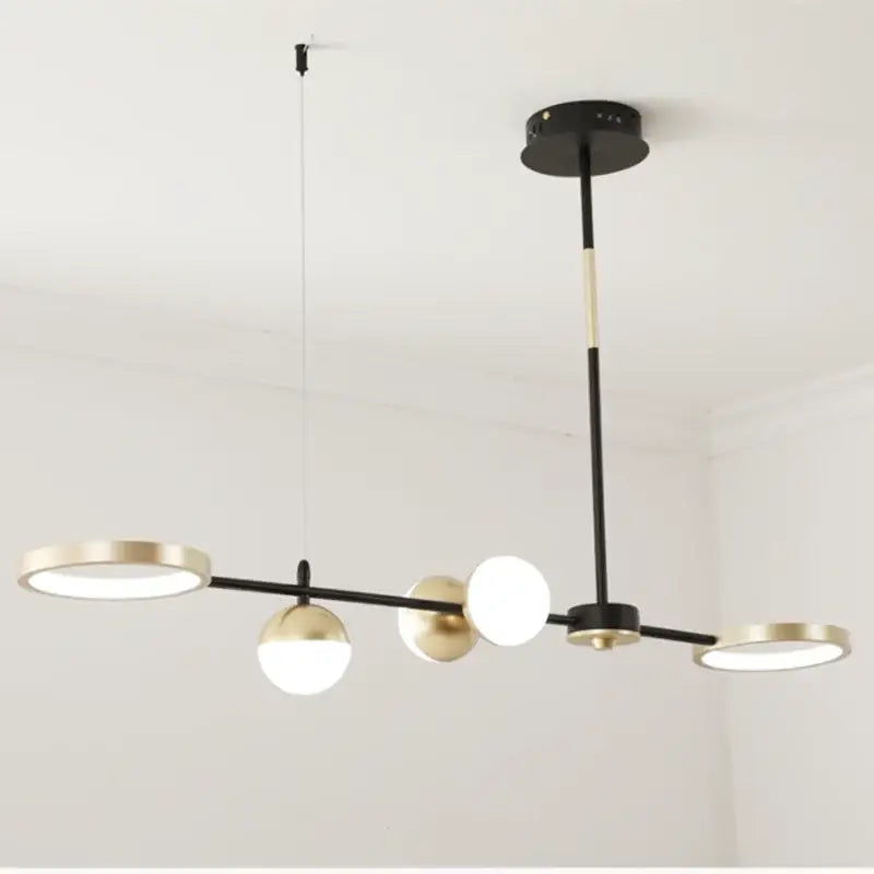 Modern black gold minimalist chandelier featuring circular and spherical illuminated fixtures for dining room decorbites black gold