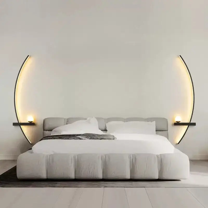 Modern gray upholstered bed with tufted headboard flanked by decorbites black gold modern wall sconce emitting warm light