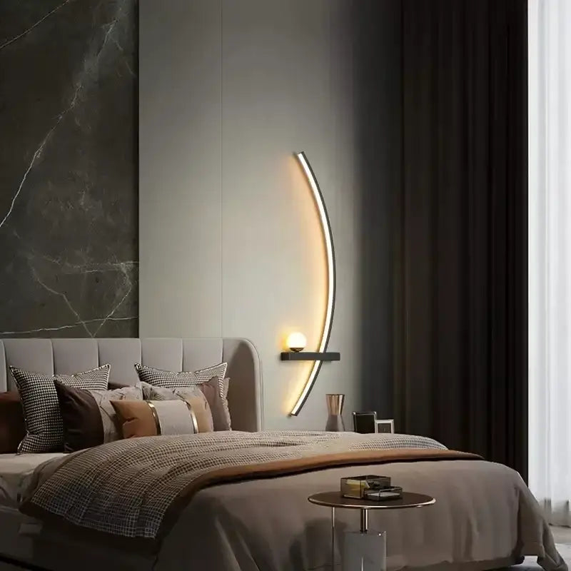 DecorBites black gold modern wall sconce with a crescent-shaped metallic frame and warm ambient indoor lighting