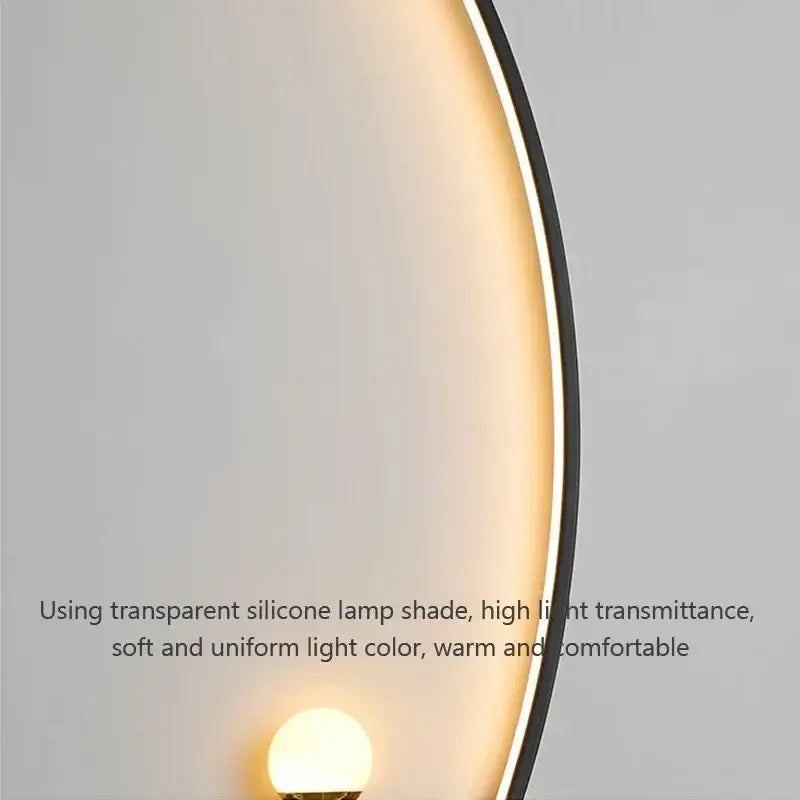 A decorbites black gold modern wall sconce with a transparent silicone shade emitting warm soft glow for indoor use