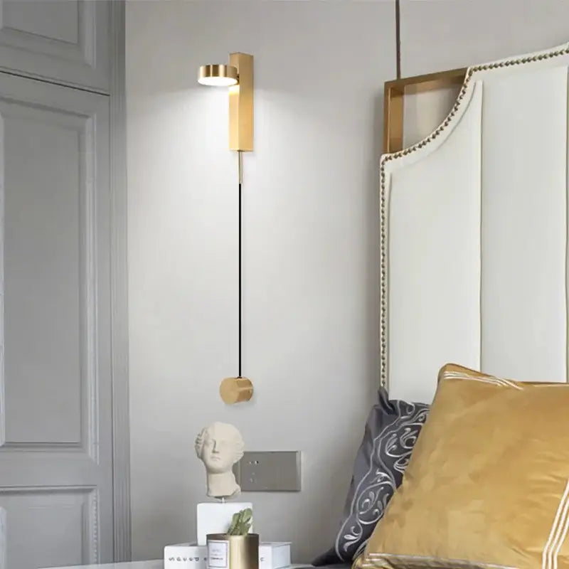 Modern gold-toned decorbites black gold rotating wall lamp with sleek vertical design and circular led fixture for bedroom use