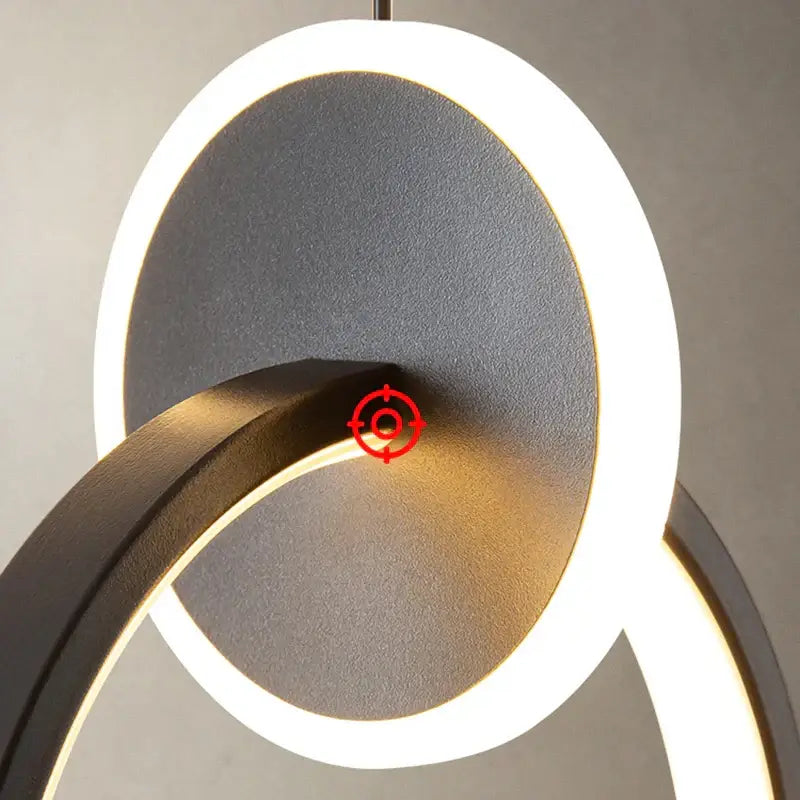 Modern minimalist DecorBites black gold pendant light with sleek black and white matte circular rings for bedside use