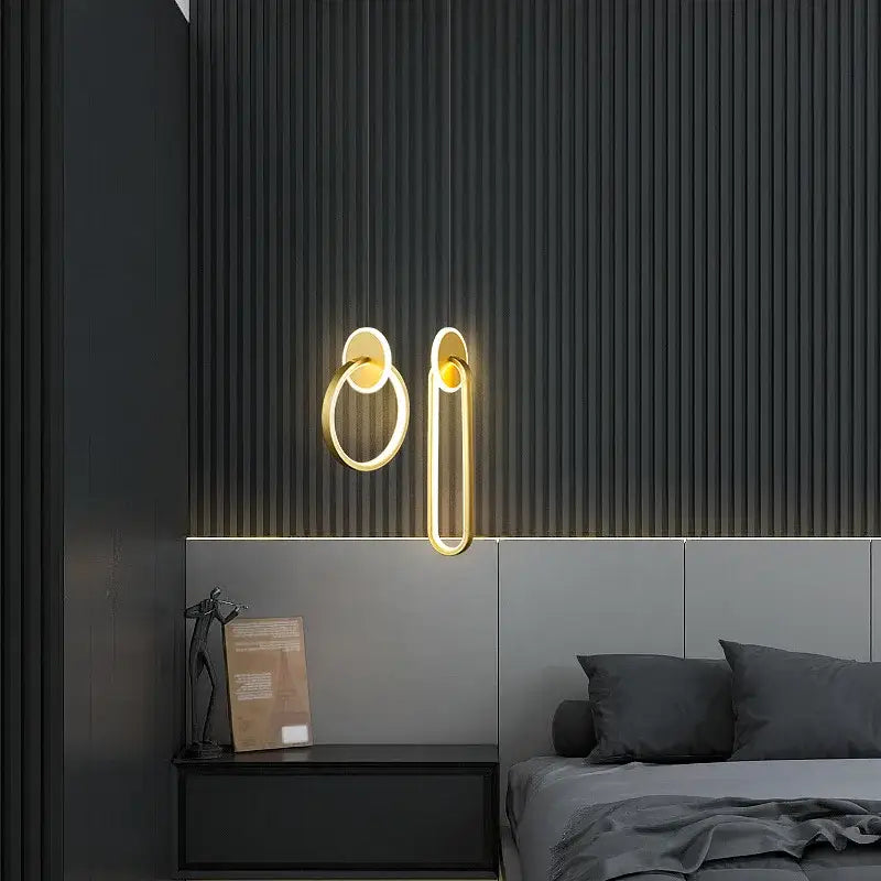 Gold-toned minimalist wall sconces with modern ring and elongated oval design complement decorbites black gold pendant light