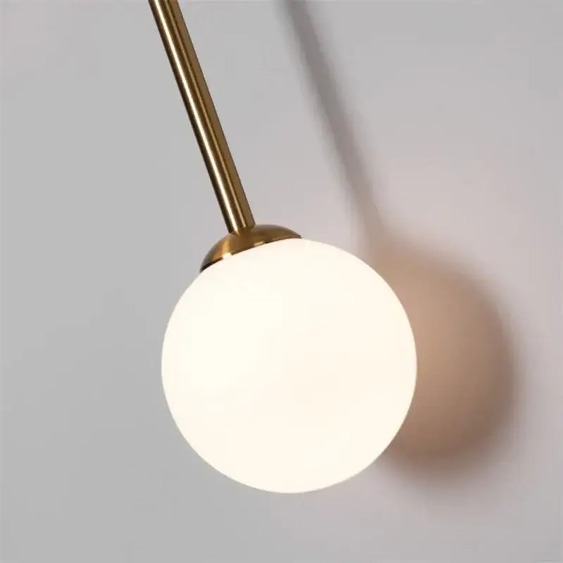 Decorbites black golden wall sconce with polished brass stem and frosted glass globe for foyer and bedroom lighting