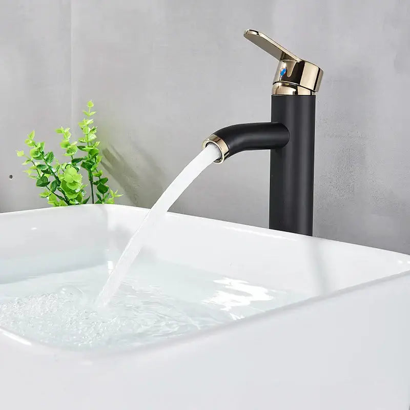 DecorBites black golden single handle basin faucet with black matte finish and gold accents flowing water into white sink