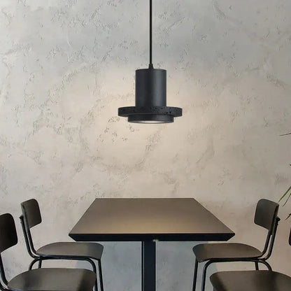 Black cylindrical pendant light with textured matte finish and circular base from decorbites black hole stone chandelier