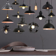 A collection of decorbites black industrial pendant lights featuring dome-shaped and wire cage shades for kitchen island decor