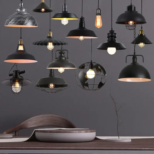 A collection of decorbites black industrial pendant lights featuring dome-shaped and wire cage shades for kitchen island decor