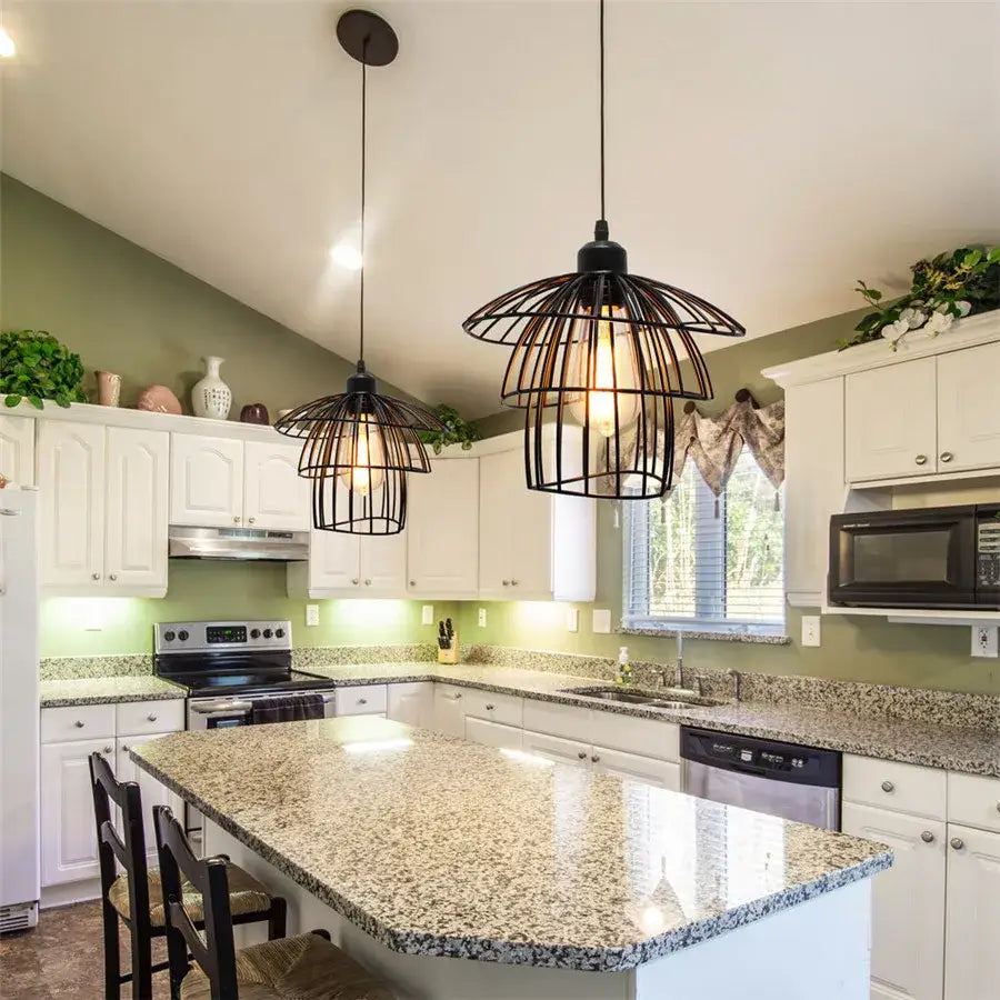 Decorbites black iron cage pendant light with exposed bulbs hanging above kitchen island for modern decor
