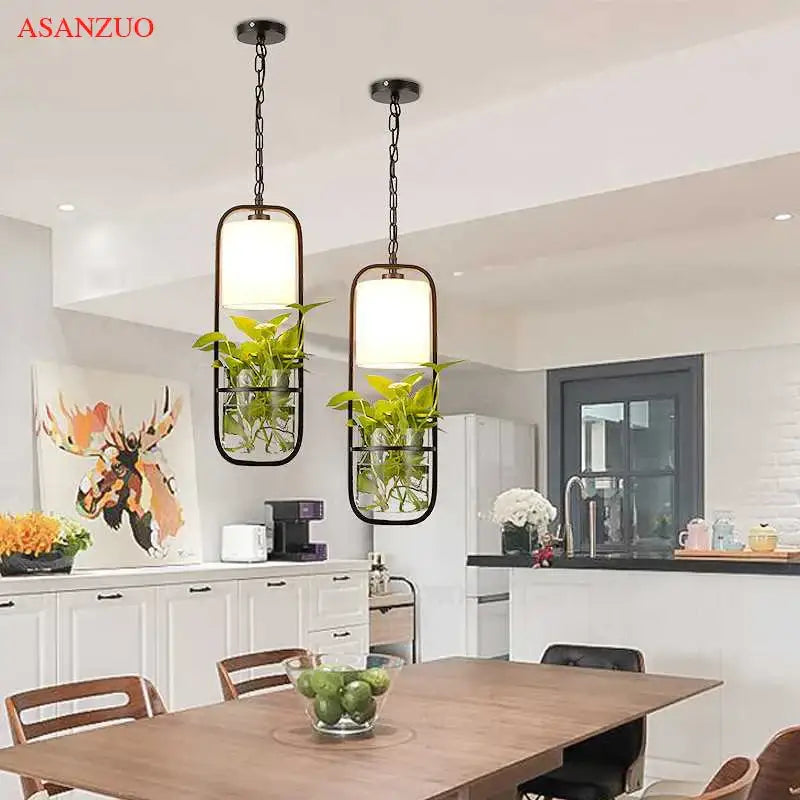 Decorbites black iron cage pendant light in black metal with rectangular frames and integrated plant holders emitting warm glow