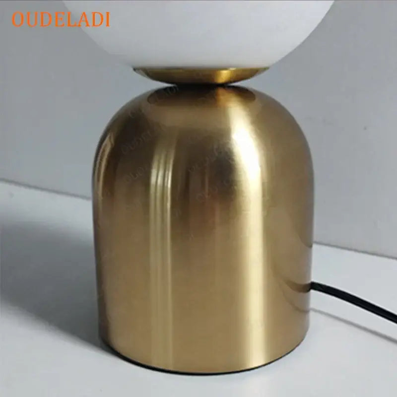 Gold-toned metallic base with frosted white glass globe on top of decorbites black iron table lamps for home decor